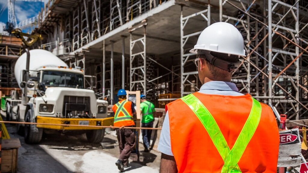 Construction worker onsite with safety vest and helmet