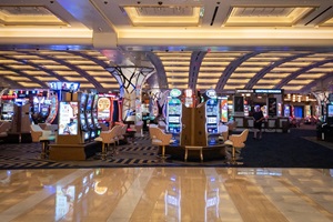 Picture of slot machines in the casino of Resorts World Las Vegas. Resorts World Las Vegas is a resort and casino on the Las Vegas Strip in Winchester, Nevada, United States. It is owned and operated by Genting Group as part of the Resorts World brand. The image showcases a row of slot machines within the casino at Resorts World Las Vegas, one of the newest and most luxurious destinations on the Las Vegas Strip. The casino floor is alive with vibrant lights, flashing screens, and the sounds of electronic gaming machines. Patrons are seated at the slot machines, engrossed in gameplay, embodying the thrill and excitement associated with gambling. Resorts World Las Vegas offers a modern take on the classic Las Vegas casino experience, blending state-of-the-art technology with opulent design. The photograph captures the essence of Las Vegas as a global entertainment capital, renowned for its nightlife, casinos, and leisure activities. The casino environment reflects the city's allure for tourists seeking gaming experiences, luxury accommodations, and high-end entertainment options.