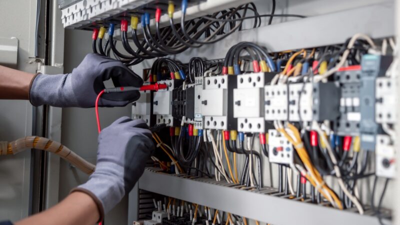 Electricity and electrical maintenance service,Electrical tests industrial electrical circuits with a multimeter in the control terminal box.